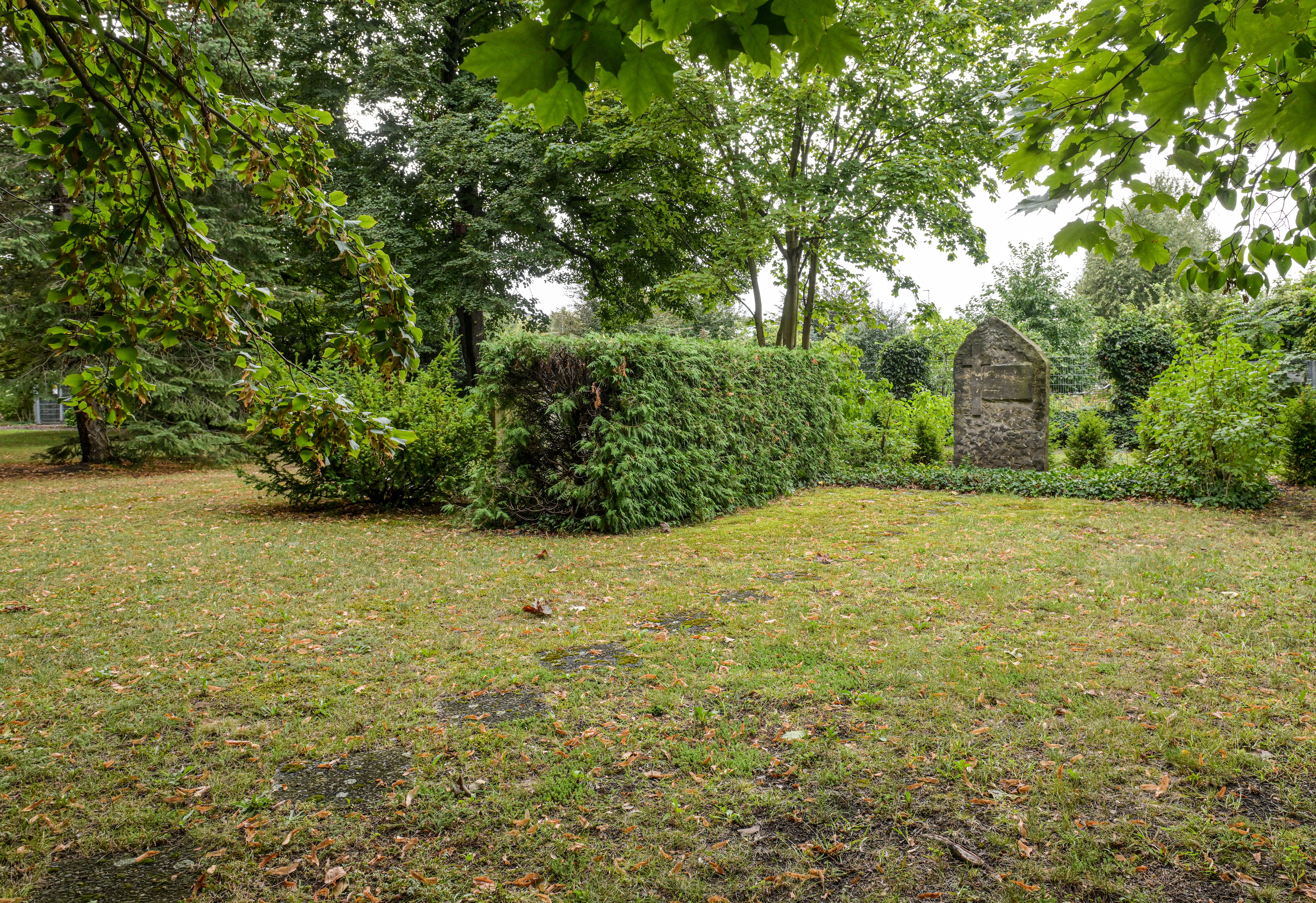 Blick auf Gedenkanlage mit Wegplatten und der inzwischen teilweise abgetragenen Hecke
© StSG/GSMP, Holm Helis, 2024